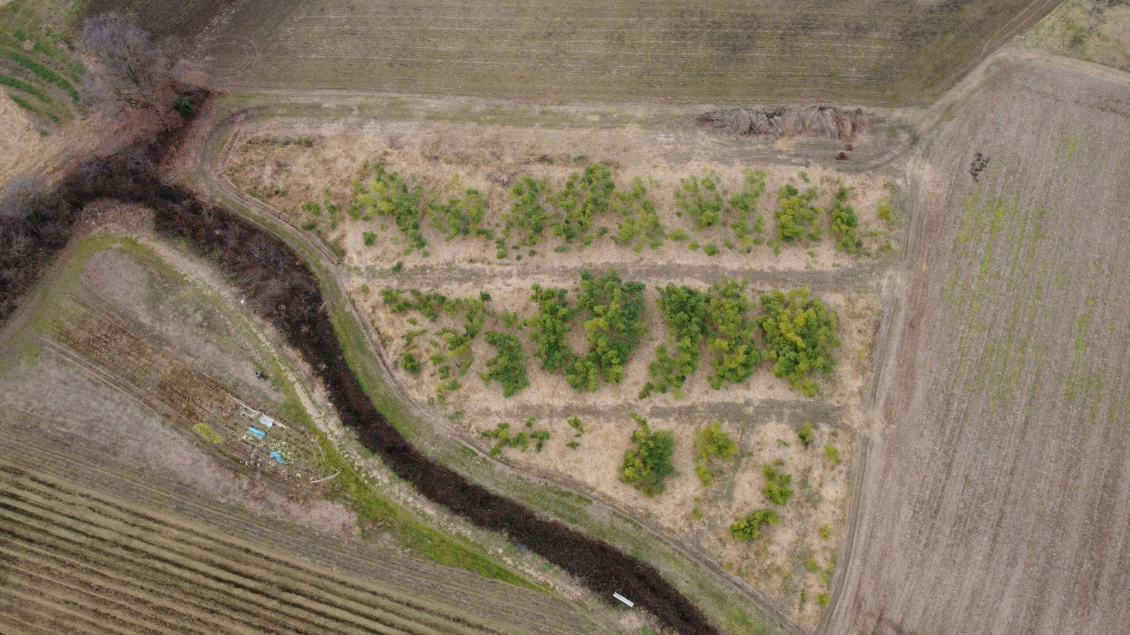 an aerial view of a field with a river running through it